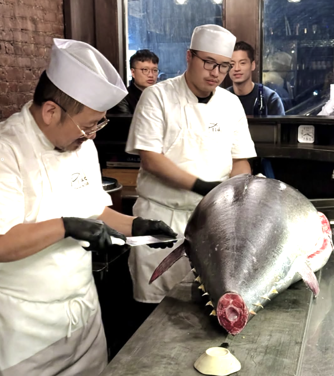 Mido chefs breaking down a whole bluefin tuna at the counter during a tuna carving night