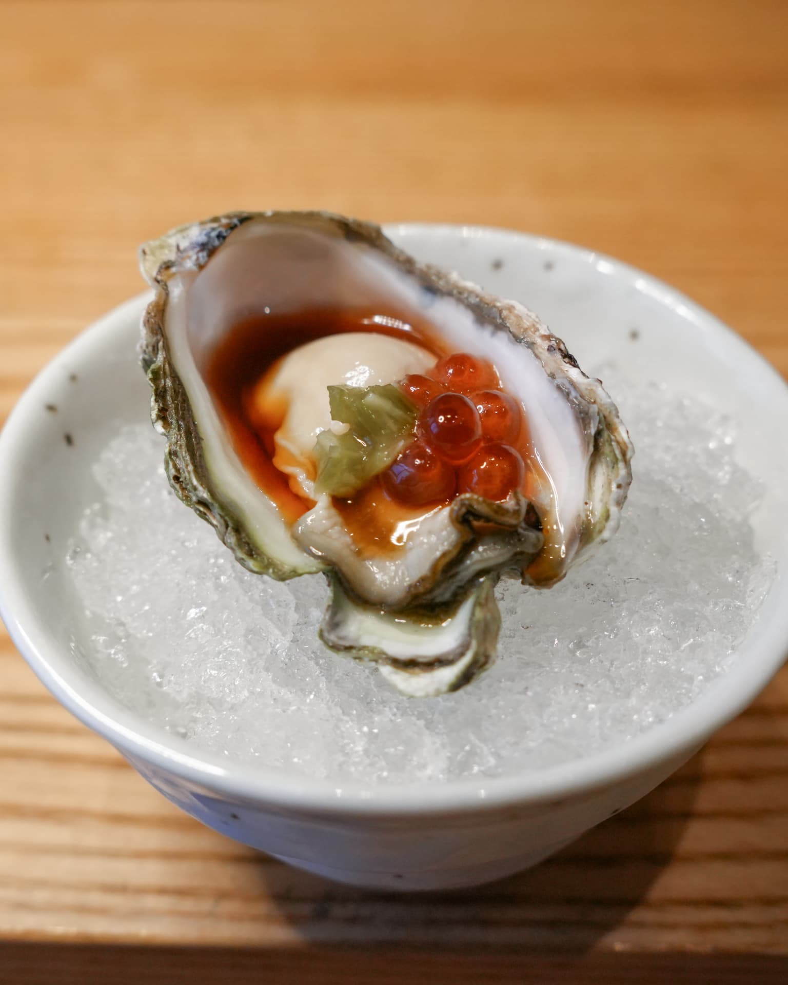 Oyster on crushed ice dressed with ponzu, ikura and yuzu